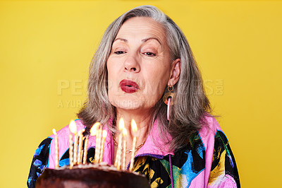 Buy stock photo Cropped shot of a confident and stylish senior woman holding her birthday cake against a yellow background