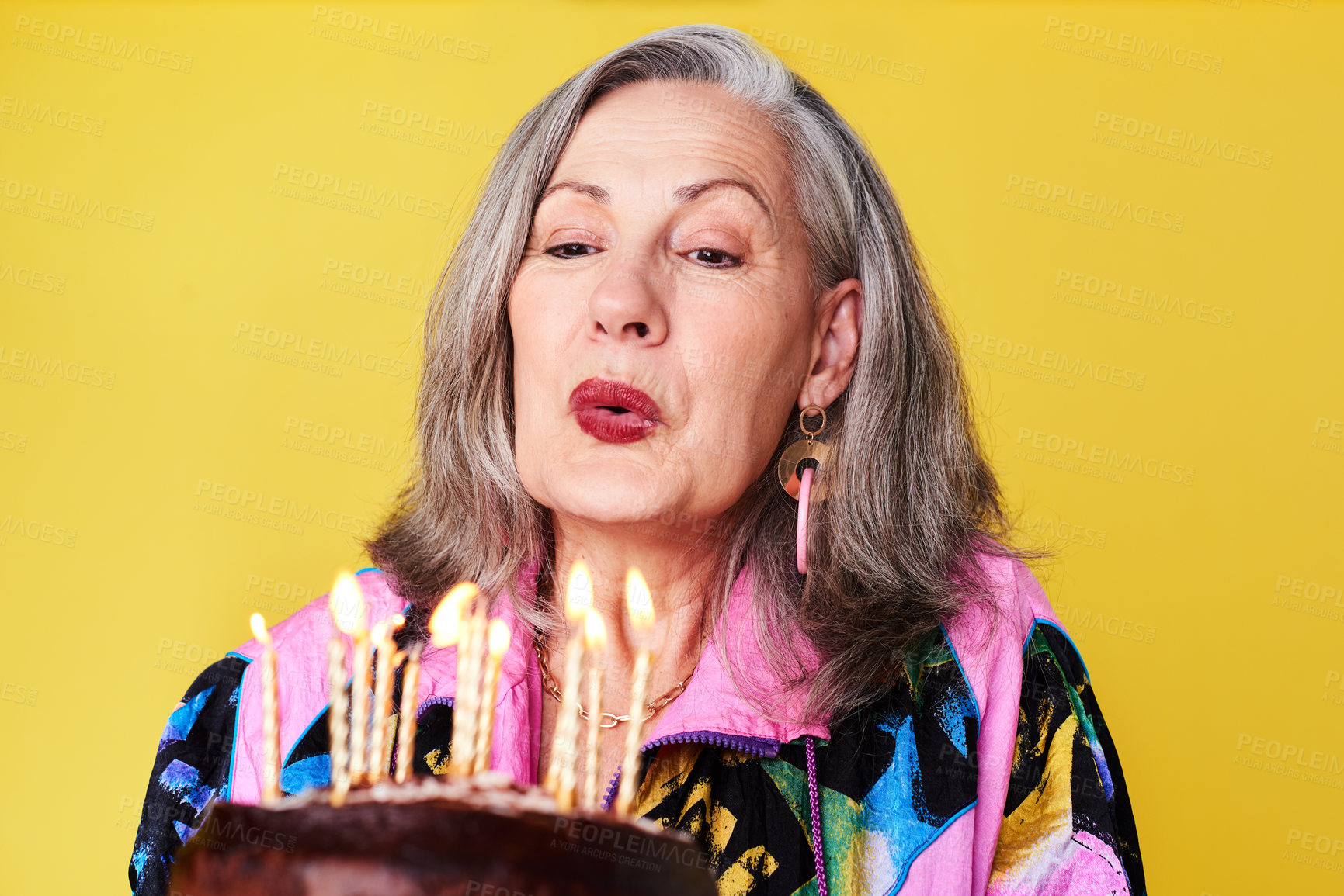 Buy stock photo Cropped shot of a confident and stylish senior woman holding her birthday cake against a yellow background