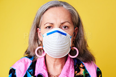 Buy stock photo Portrait of a quirky senior woman wearing a N95 face mask against a yellow background