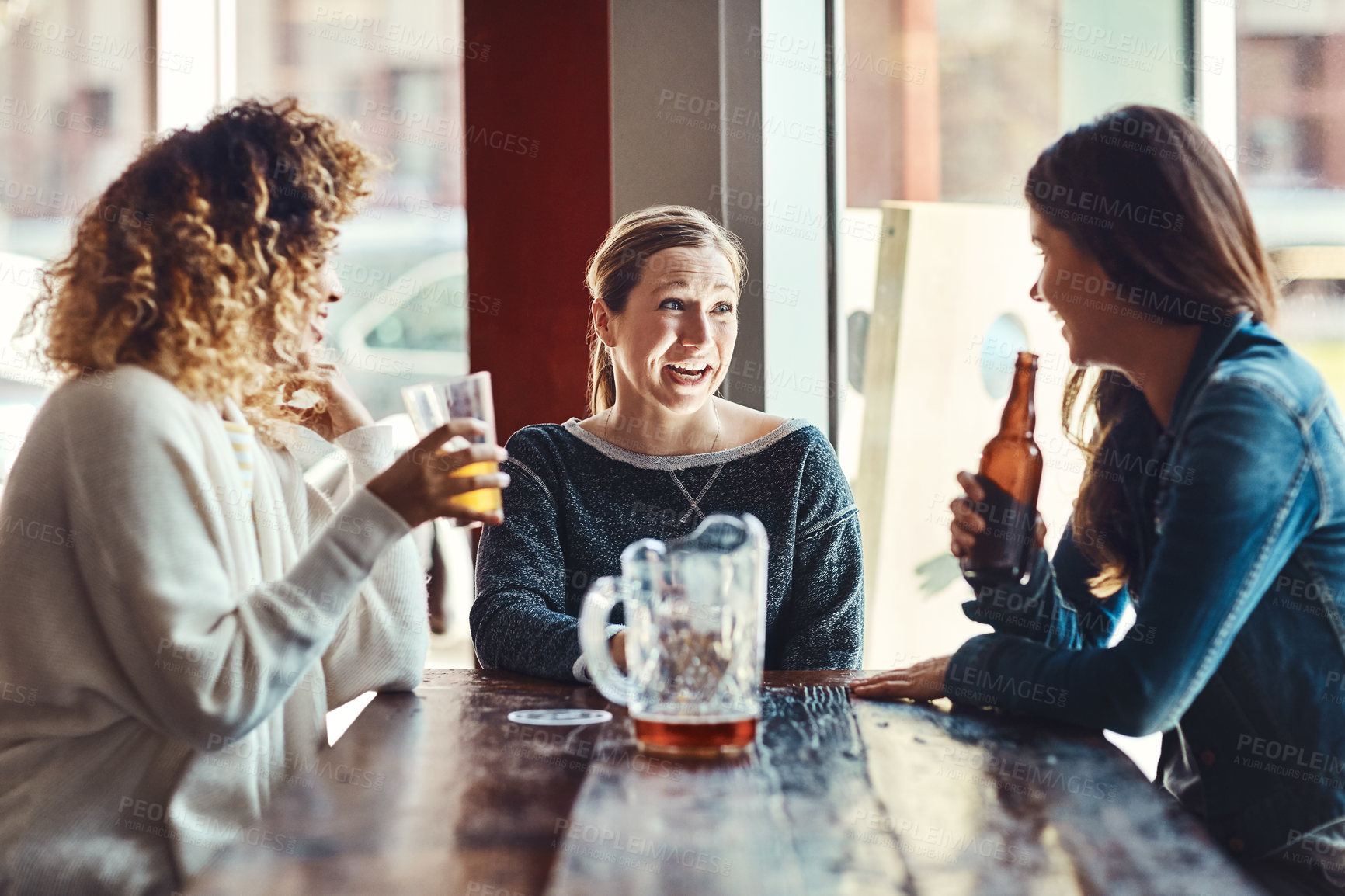Buy stock photo Women, laugh and chat with beer at bar with friends for bonding, reunion or conversation at happy hour. People, drinks and smile with funny gossip, discussion and social gathering with alcohol at pub