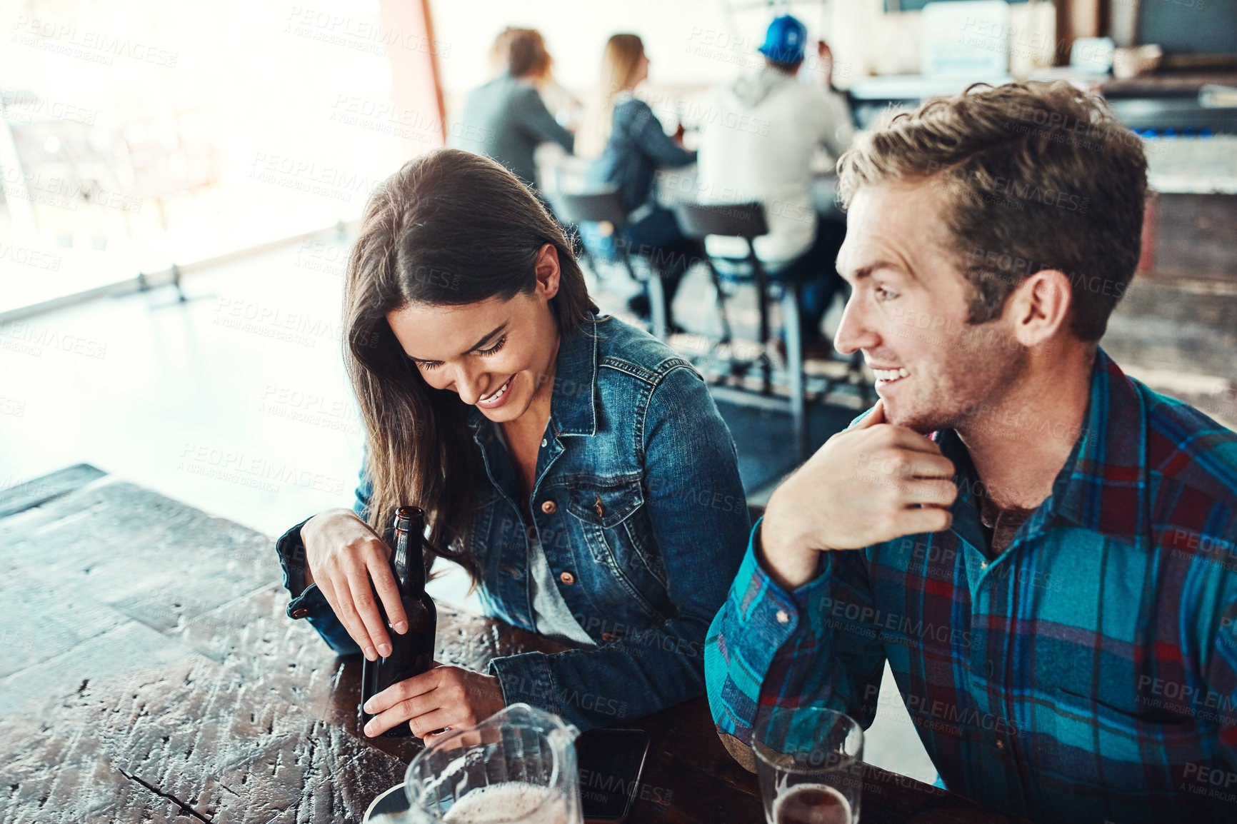 Buy stock photo Date, couple and restaurant with drink, laughing and happy from romance and talk together. Pub, joke and people with conversation, love and bonding with beer and alcohol at bar for anniversary