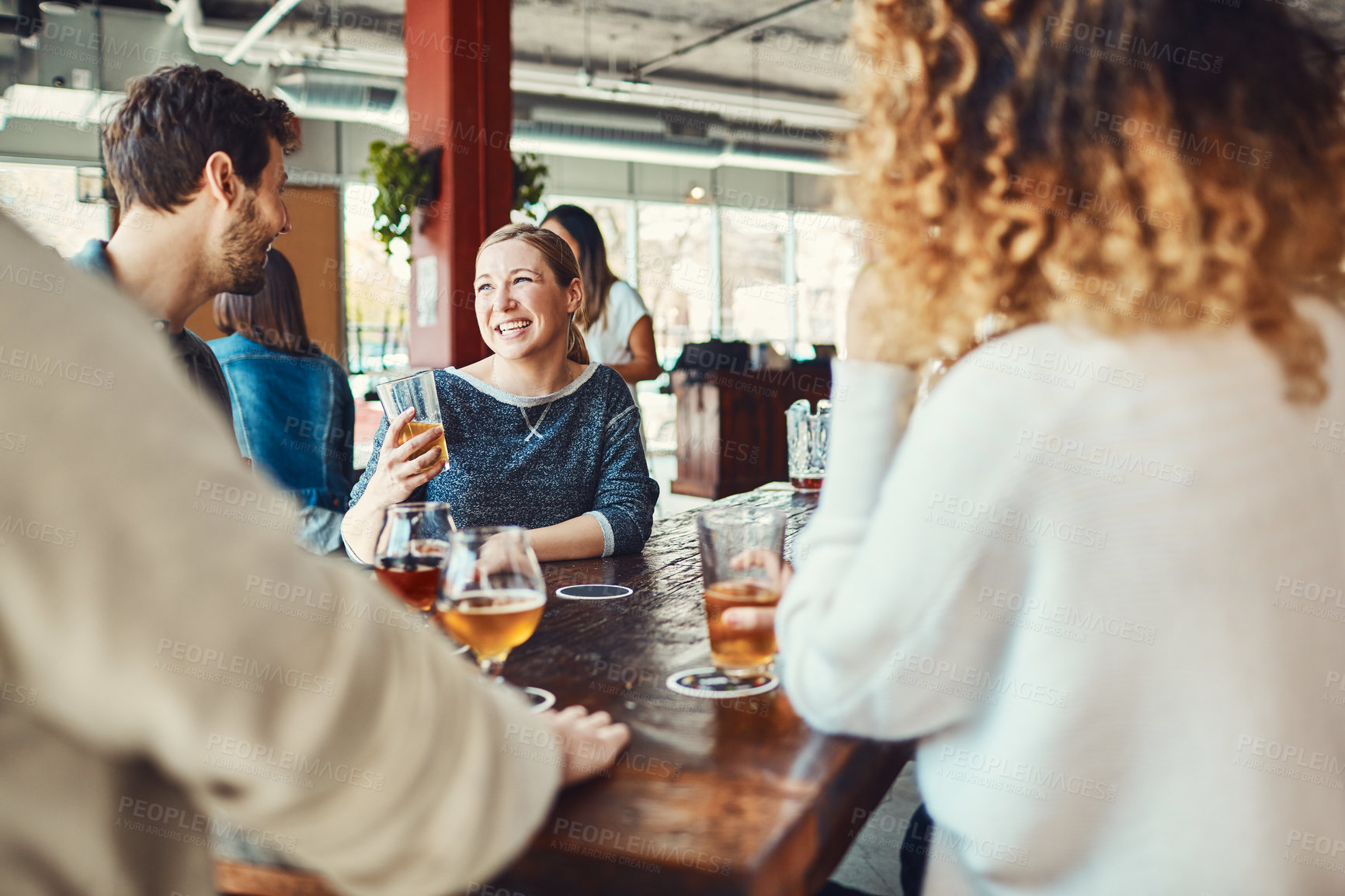 Buy stock photo Shot of a group of friends enjoying some beers at a bar