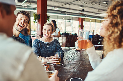 Buy stock photo Shot of a group of friends enjoying some beers at a bar