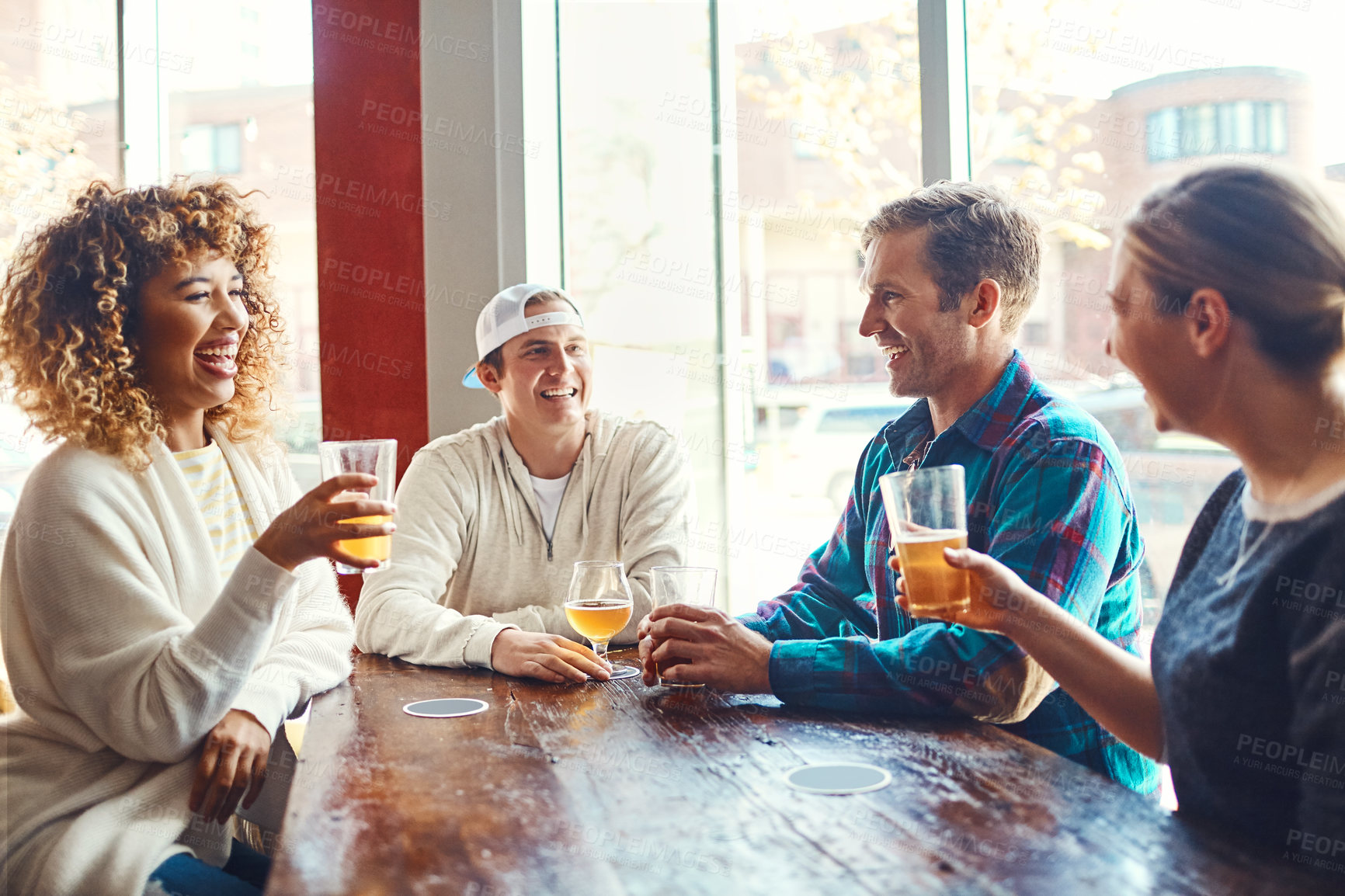 Buy stock photo Shot of a group of friends enjoying some beers at a bar