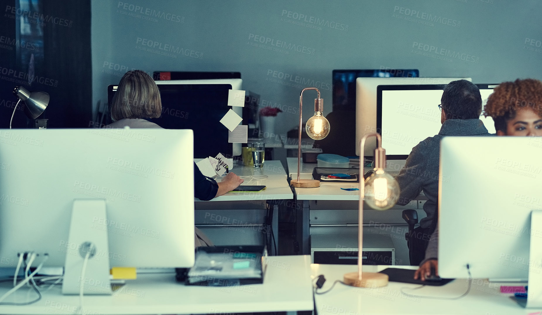 Buy stock photo Shot of a group of businesspeople working late in an office