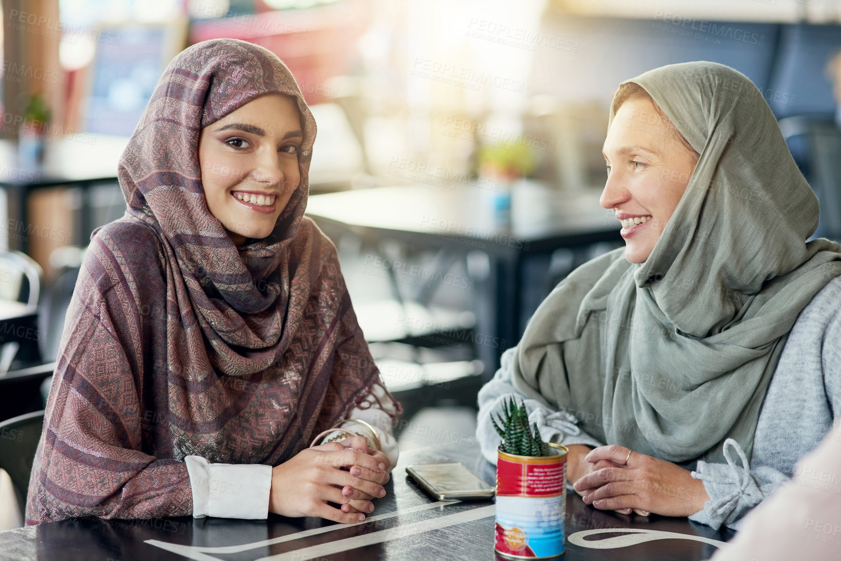 Buy stock photo Portrait of a happy young woman spending time with her friend in a cafe