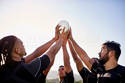 Buy stock photo Cropped shot of a handsome group of sportsmen holding a rugby ball together before playing rugby
