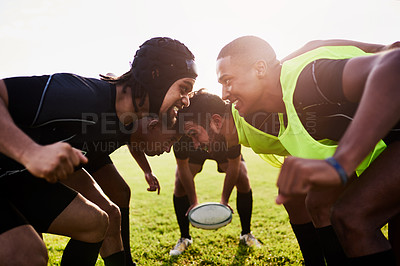 Buy stock photo Cropped shot of a diverse group of sportsmen performing a scrum during a rugby game during the day