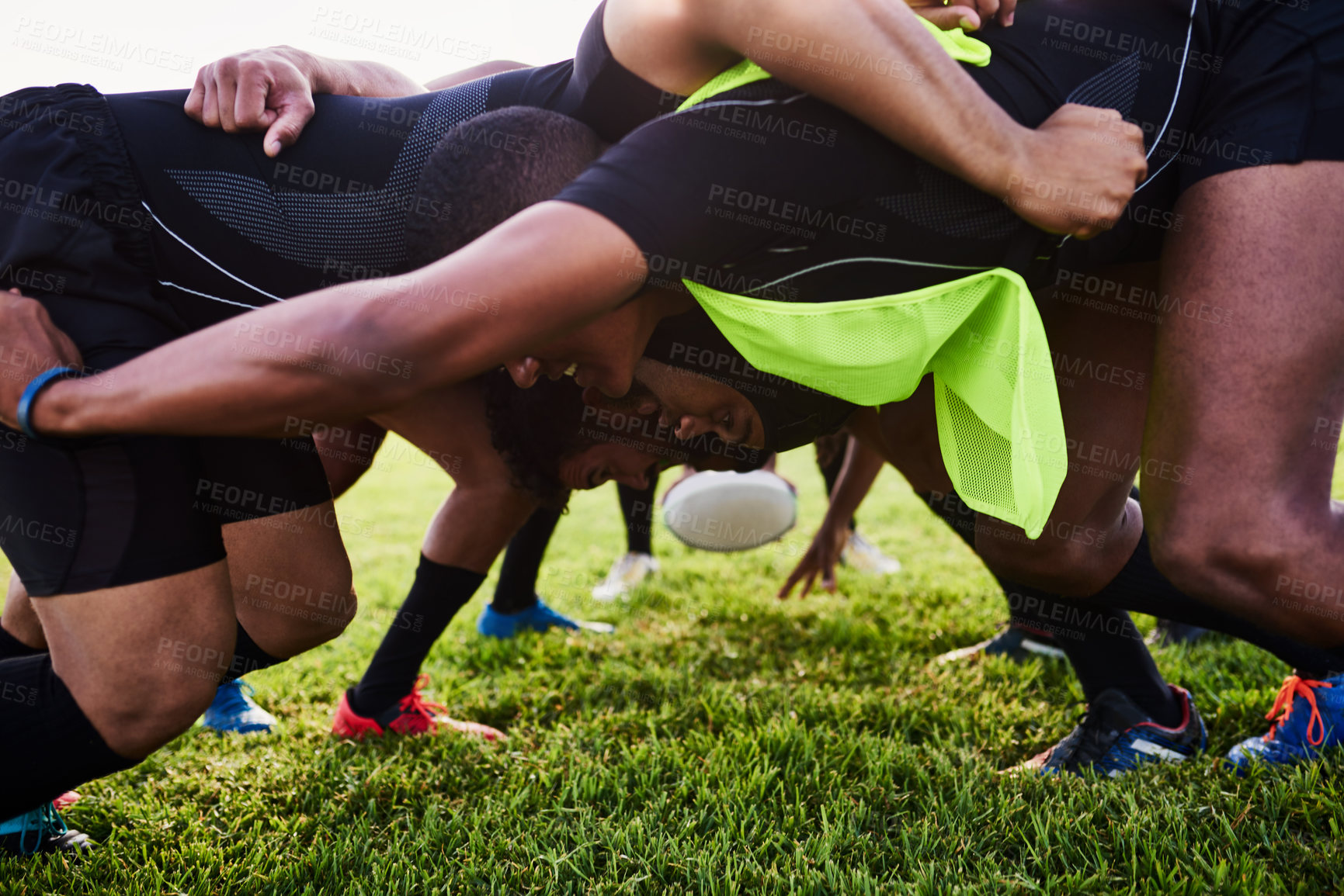 Buy stock photo Cropped shot of a diverse group of sportsmen performing a scrum during a rugby game during the day