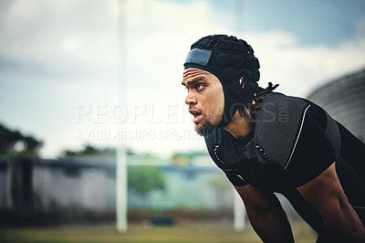 Buy stock photo Cropped shot of a handsome young rugby player taking a break while on the playing field during the day