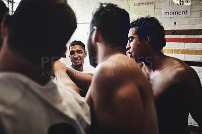 Buy stock photo Cropped shot of a group of handsome young rugby players standing together in a huddle in a locker room