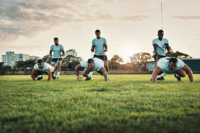 Buy stock photo Full length shot of a group of young rugby players training with bands on the field during the day