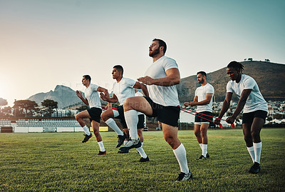 Buy stock photo Full length shot of a group of young rugby players training with bands on the field during the day