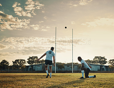 Buy stock photo Full length shot of two young rugby players training together on the field during the day