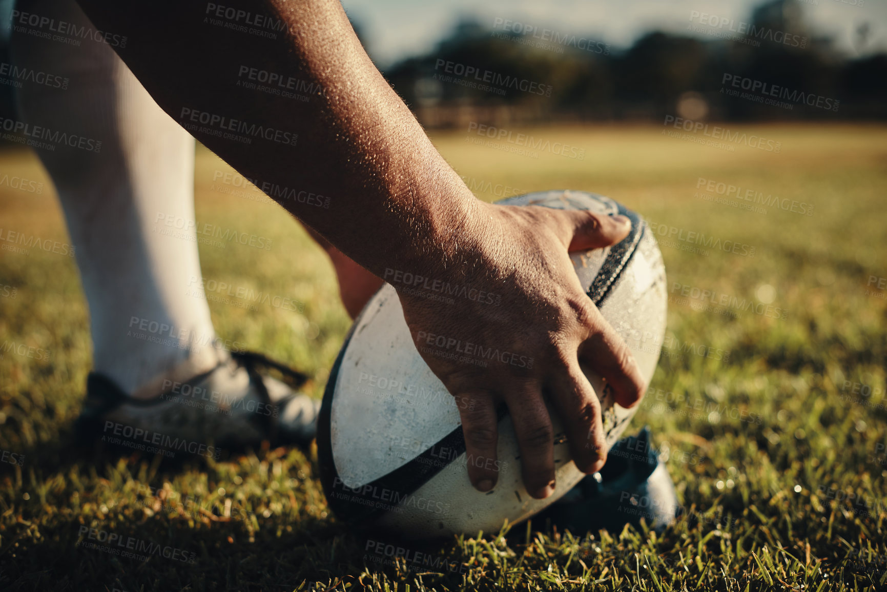 Buy stock photo Cropped shot of an unrecognizable rugby player preparing for a kick on the field during the day