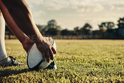 Buy stock photo Cropped shot of an unrecognizable rugby player preparing for a kick on the field during the day