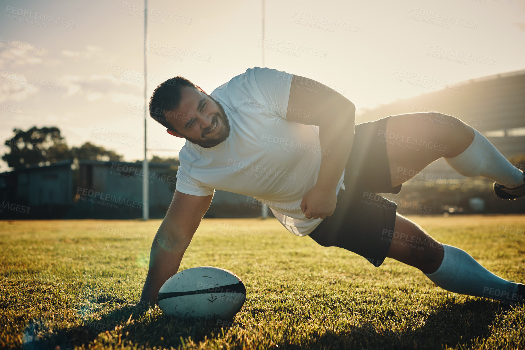 Buy stock photo Cropped shot of a handsome young rugby player training on the field during the day