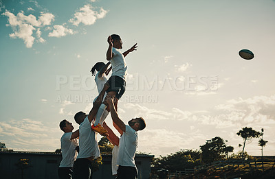Buy stock photo Rugby, team jump and lift for ball and teamwork, sport and  training for game, fitness and exercise or sports performance with blue sky. Group, men and lifting man to catch and professional match