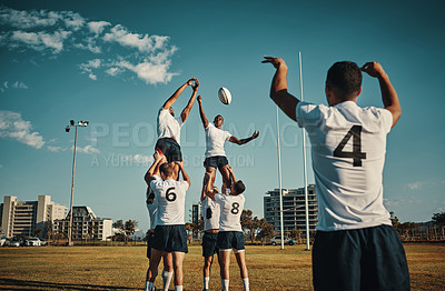Buy stock photo Team, rugby and jump or lift, ball and teamwork or sport, training for game and fitness, exercise or sports performance with blue sky. Group, men and lifting man to catch and professional match