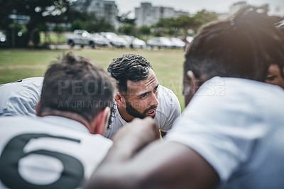 Buy stock photo Cropped shot of a focused young rugby team forming a huddle before a match outside on a rugby field