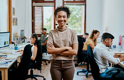 Buy stock photo Portrait of a confident young businesswoman working in a modern office with her team in the background