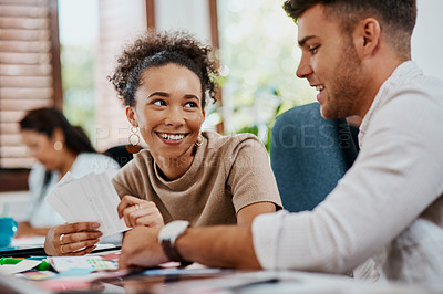 Buy stock photo Shot of a young businessman and businesswoman working together on a task in a modern office.