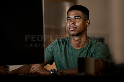 Buy stock photo Shot of a young businessman using a computer in a modern office at night