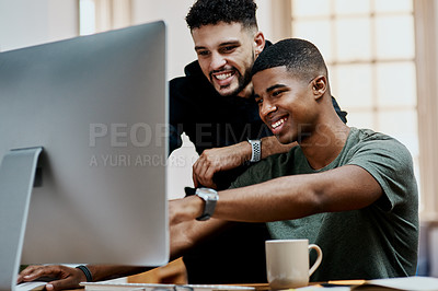 Buy stock photo Shot of two young businessmen using a computer together in a modern office