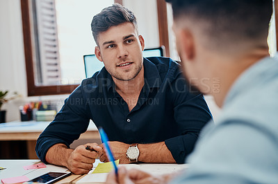 Buy stock photo Shot of two young businessmen working together on a task in a modern office