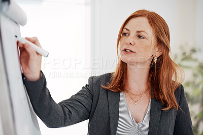 Buy stock photo Shot of a mature businesswoman using a whiteboard while giving a presentation in an office