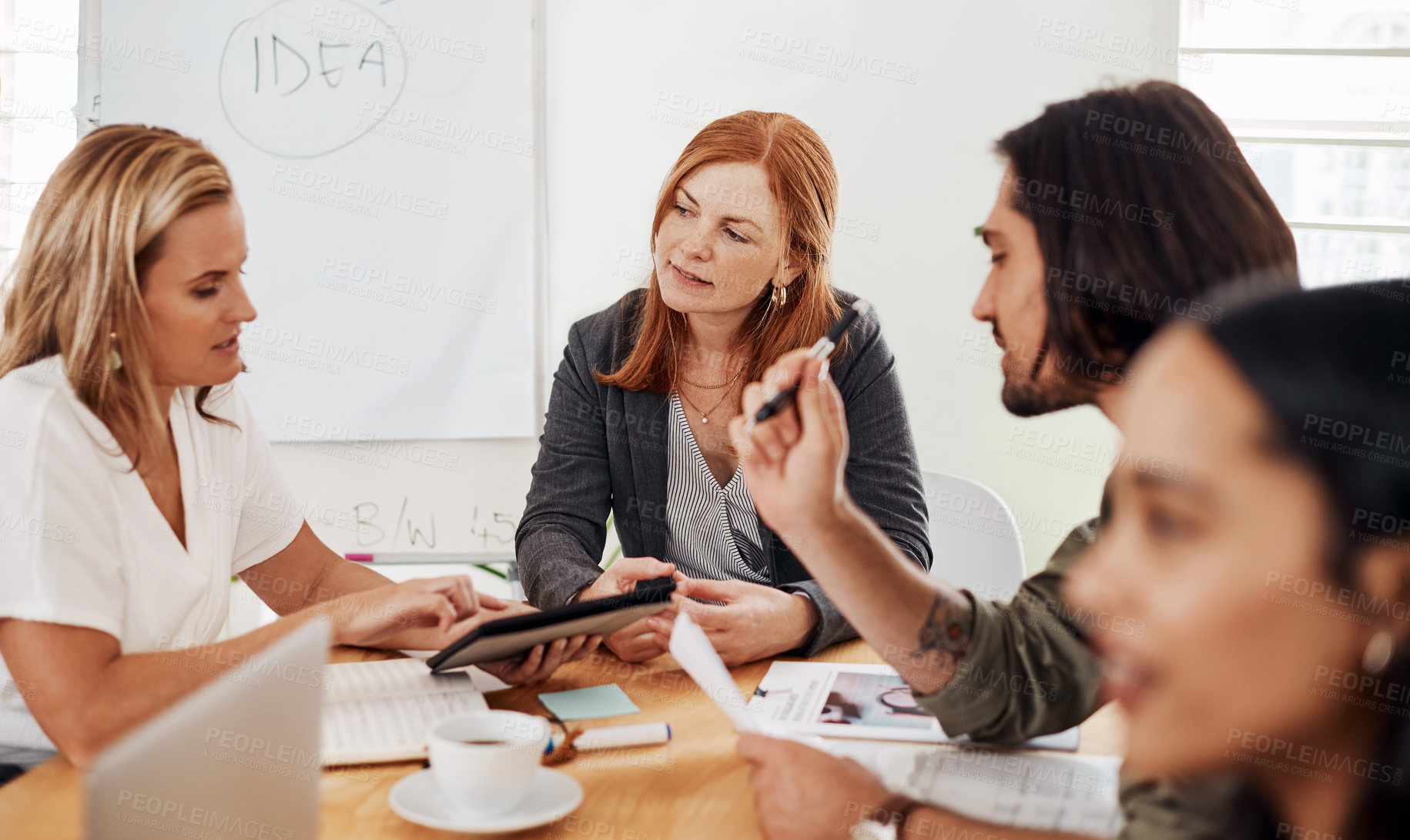 Buy stock photo Shot of a mature businesswoman having a meeting with her colleagues in an office
