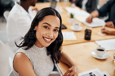 Buy stock photo Portrait of a young businesswoman sitting in an office with her colleagues in the background