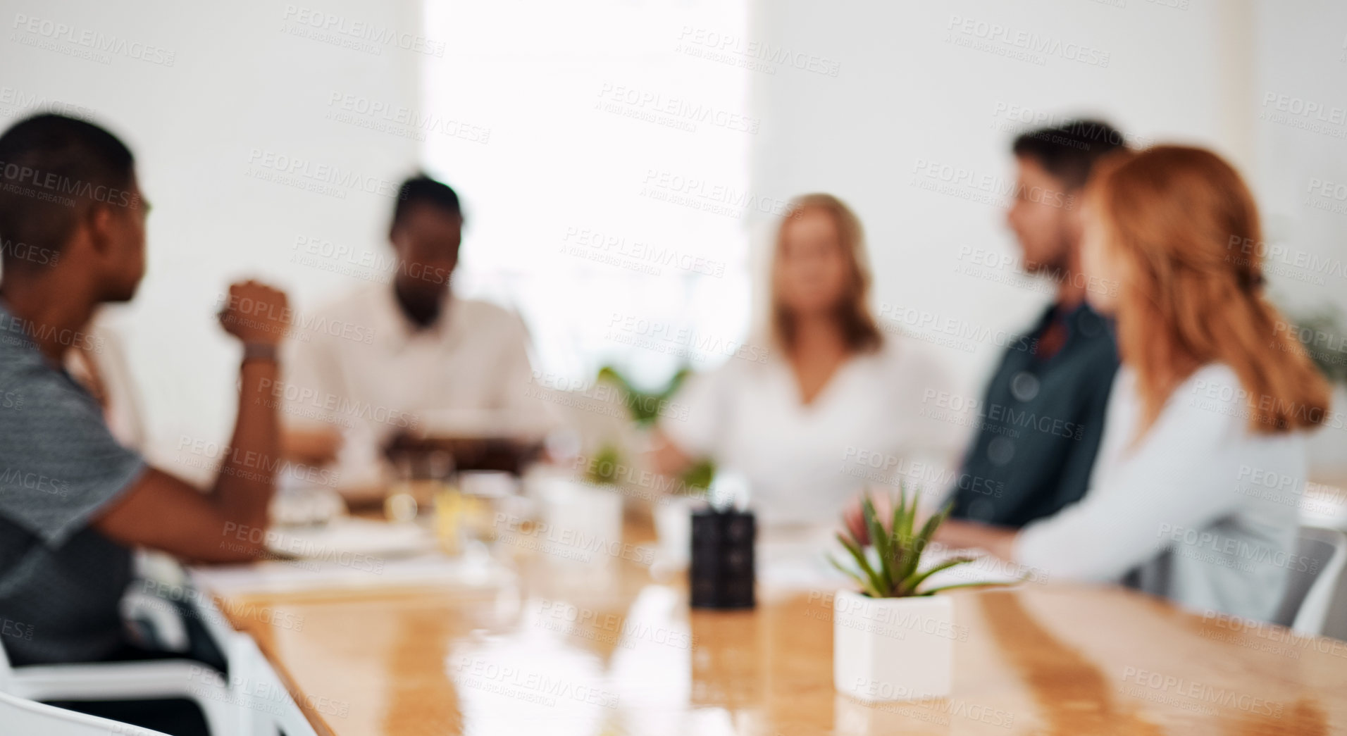 Buy stock photo Defocused shot of a group of businesspeople having a meeting in an office
