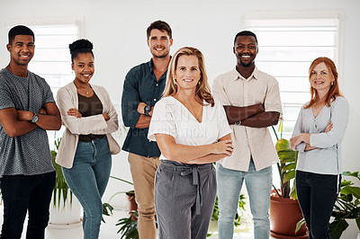Buy stock photo Portrait of a mature businesswoman standing in an office with her colleagues in the background