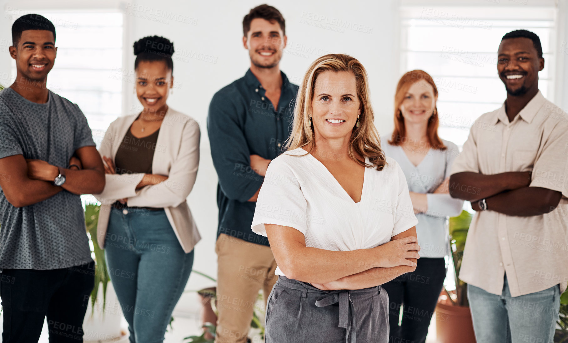 Buy stock photo Portrait of a mature businesswoman standing in an office with her colleagues in the background