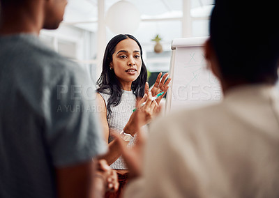 Buy stock photo Cropped shot of an attractive young businesswoman using a visual aid to brainstorm with her colleagues in the office
