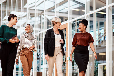 Buy stock photo Shot of a group of businesswomen walking alongside each other in an office