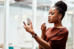 Adding a touch of lipstick to complete her boss look