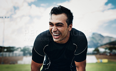Buy stock photo Cropped shot of a handsome young man smiling while taking a break on the field during the day