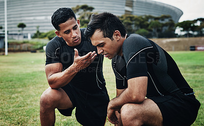 Buy stock photo Cropped shot of two handsome young rugby players looking upset during   a conversation on the field