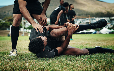 Buy stock photo Cropped shot of a handsome young rugby player suffering with an injury on the field