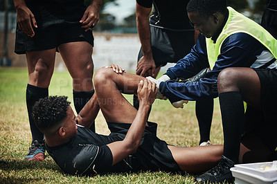 Buy stock photo Cropped shot of a young rugby player receiving first aid assistance on the field