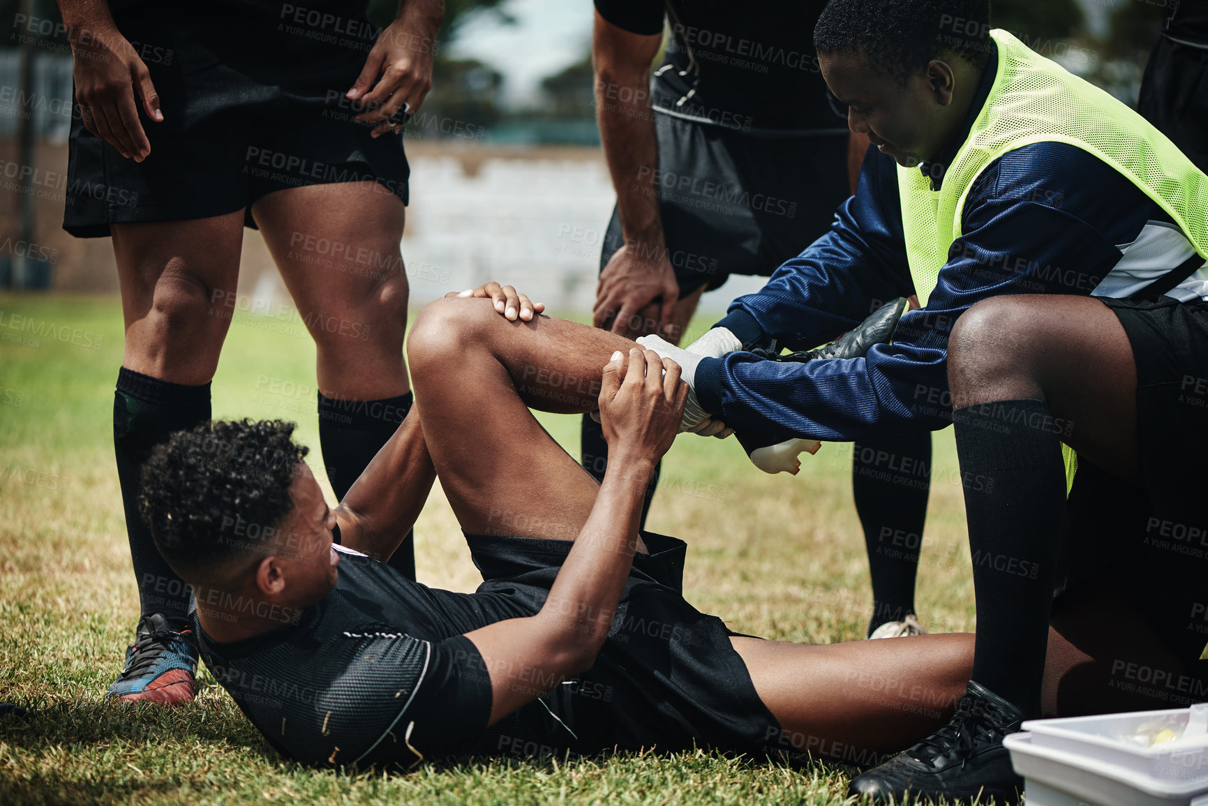 Buy stock photo Cropped shot of a young rugby player receiving first aid assistance on the field