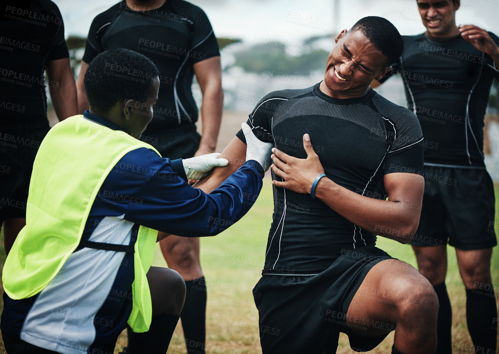 Buy stock photo Cropped shot of a young rugby player receiving first aid assistance on the field