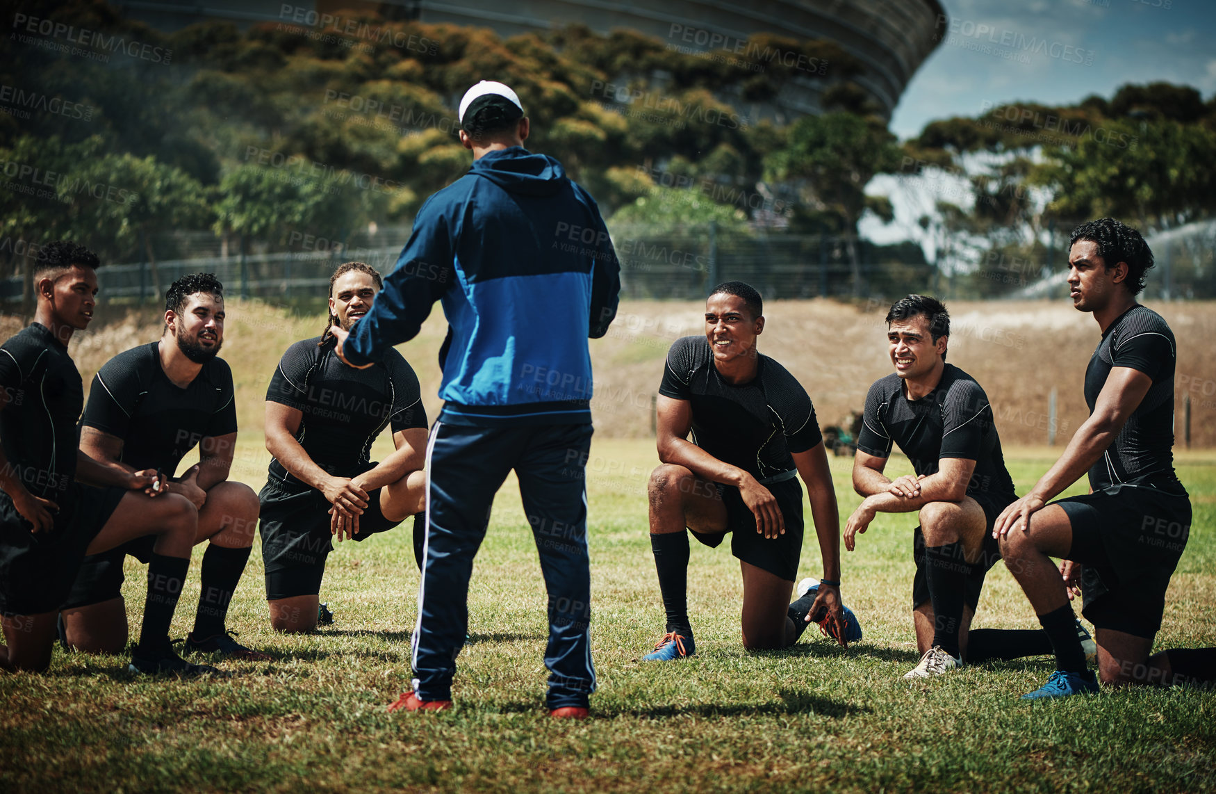 Buy stock photo Cropped shot of a team of rugby players training with their coach on the field during the day