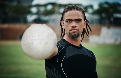 Buy stock photo Cropped portrait of a handsome young rugby player holding a rugby ball while standing on the field