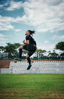 Buy stock photo Full length shot of a handsome young rugby player jumping into the air while cheering on the field