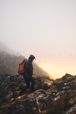 Buy stock photo Shot of a man wearing his backpack while out for a hike in the mountains