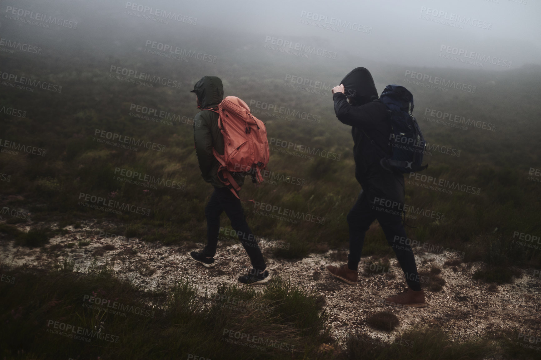 Buy stock photo Shot of two male friends out for a hike on a misty day