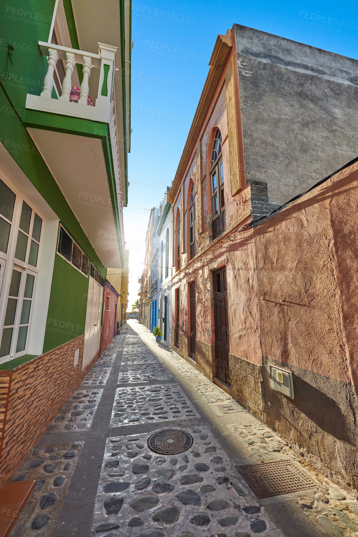 Buy stock photo Empty cobbled street in a rural European tourist town. A quiet narrow alley way with colorful apartment buildings or houses. Hidden side street with traditional architecture in Santa Cruz de La Palma